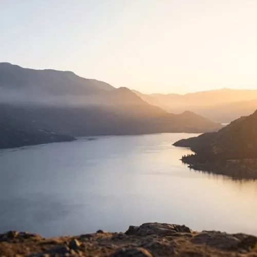 A peaceful, panoramic view of the Okanagan Valley and lake in British Columbia during a golden sunrise. This serene Canadian landscape represents hope, clarity, and the journey toward mental wellness for those navigating bipolar disorder in Canada